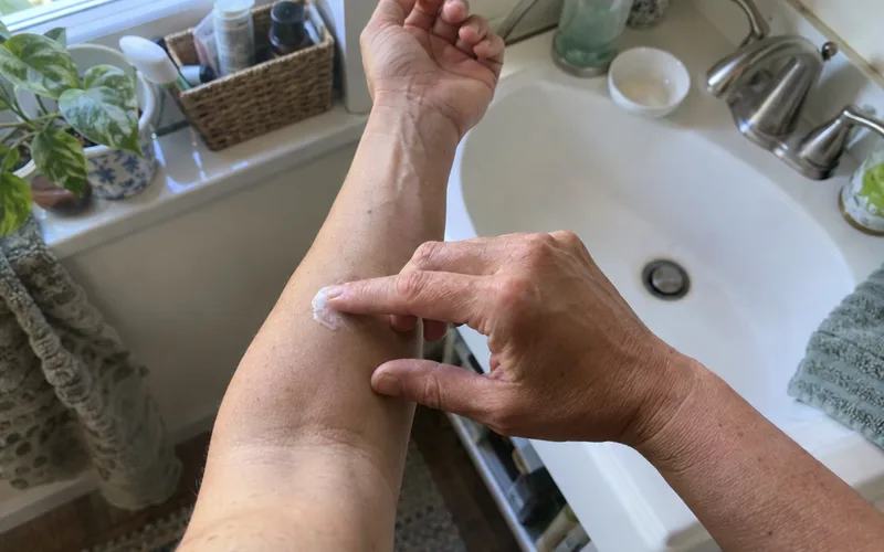 Fingertip dabbing a little tea tree shampoo on the inner forearm for a patch test